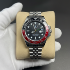 GMT style watch with red black Pepsi bezel hero shot on beige cushion